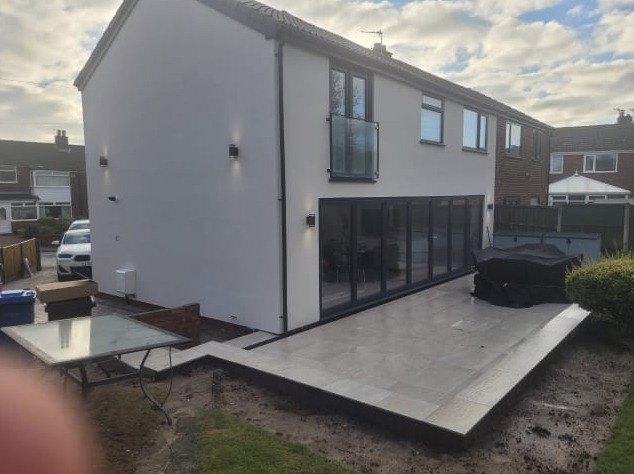 Rendered two storey rear extension with anthracite bifold doors and a new porcelain patio