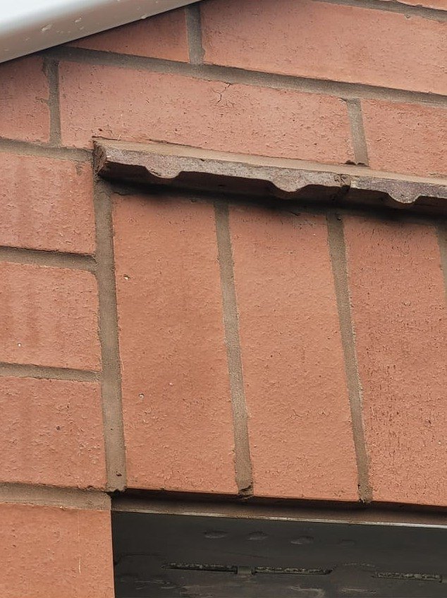 Concrete lintel bedded in over a new opening in fresh brickwork