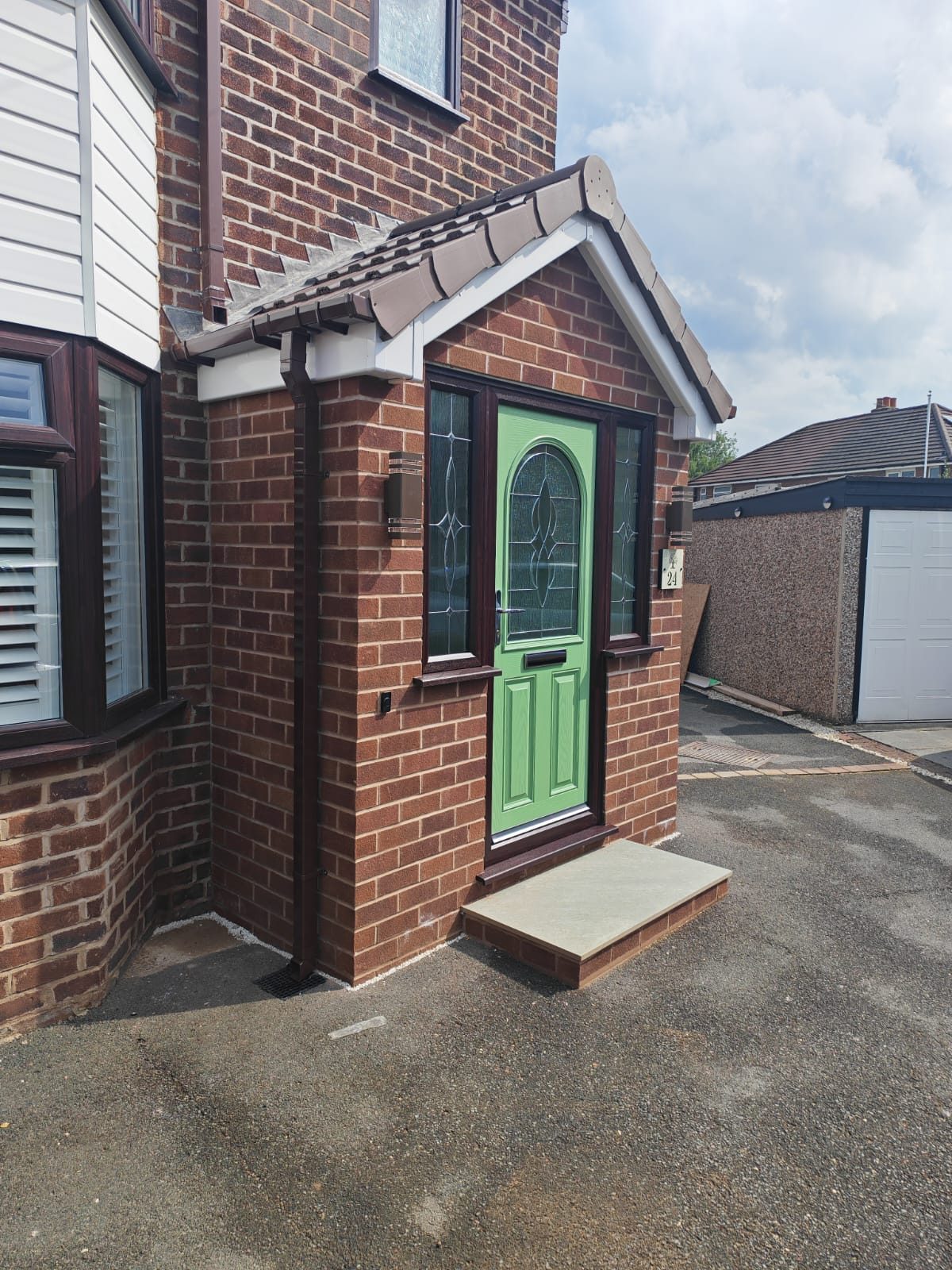 Brick porch built off the front corner of the house with a tiled pitched roof