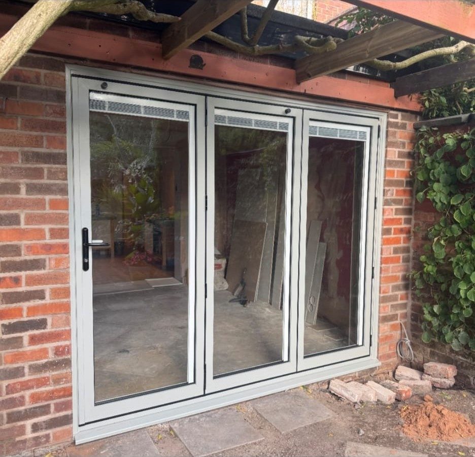 White bifold doors fitted in a brick opening